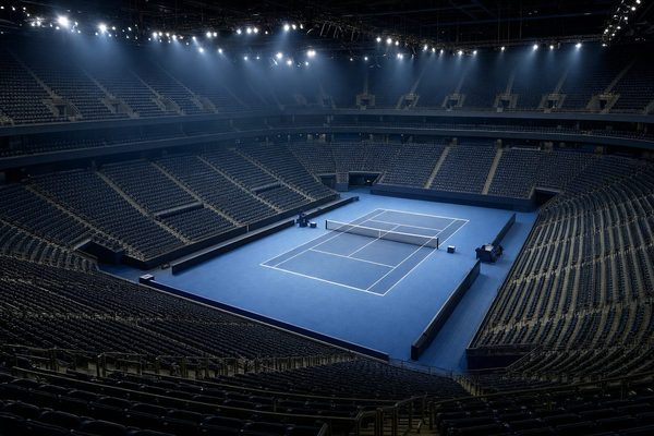 ATP Finals - arena indoor con campo in cemento blu e tribune vuote sotto i riflettori