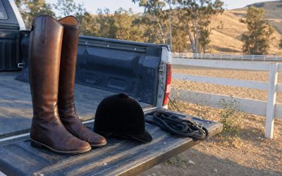 Elisabetta Canalis - stivali da equitazione e cap sul cassone di un pickup davanti al campo