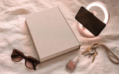 Giulia De Lellis - libro, smartphone su ring light, occhiali da sole e smalto su lino rosa