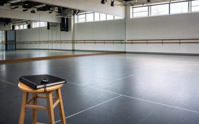 Maria De Filippi - sala prove di danza vuota con specchi, sbarra e raccoglitore su uno sgabello