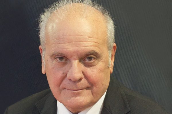 Mauro Mazza - ritratto in giacca scura e cravatta su fondo grigio, Francoforte 2023